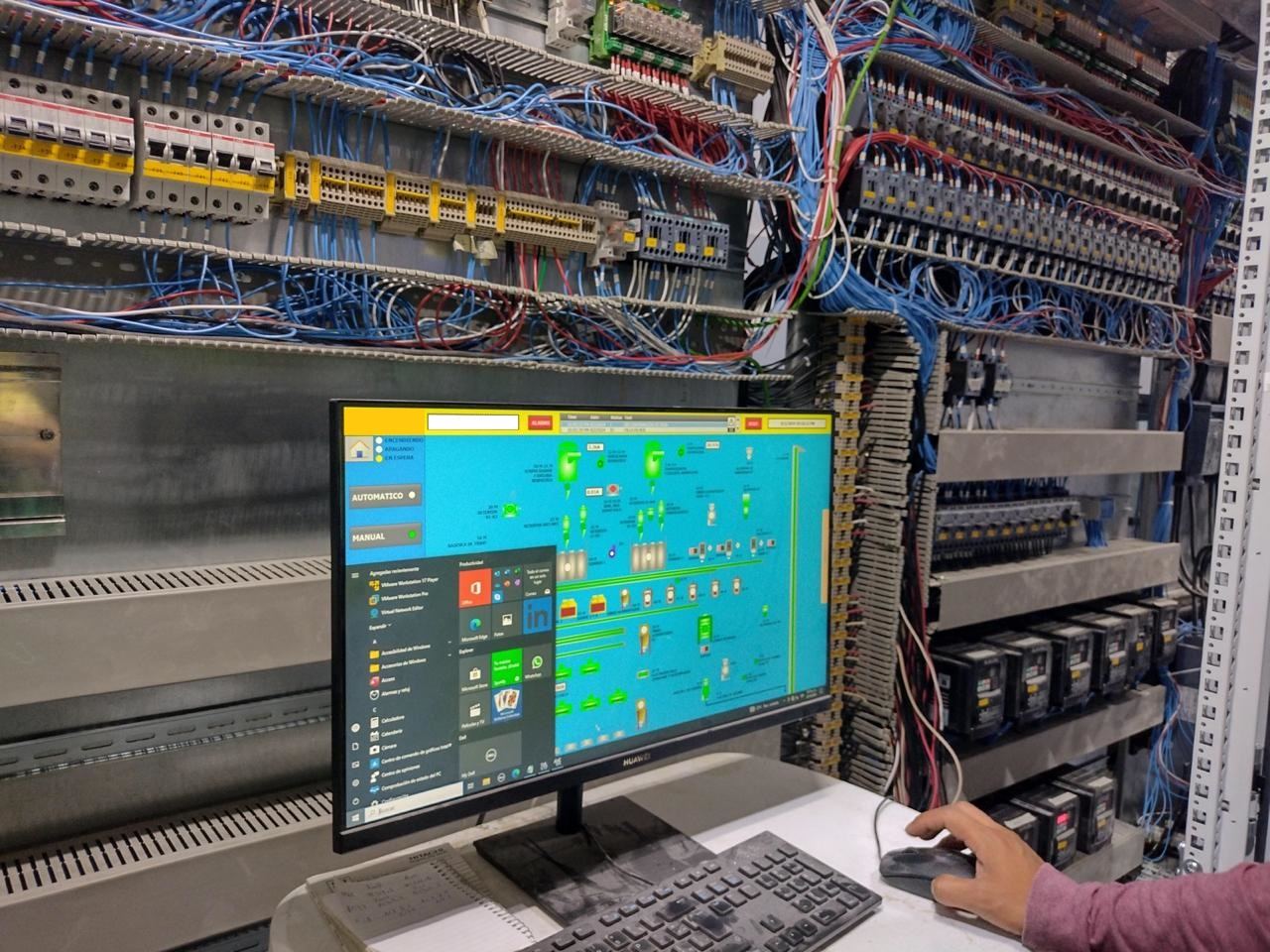 Estación SCADA junto a un tablero de control en planta